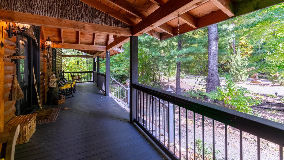 A peaceful scene featuring classic rocking chairs lined up on a wooden porch, looking out to the surrounding natural landscape. The setting invites guests to unwind, share stories, and enjoy the tranquil environment after a day of exploring nearby attractions.